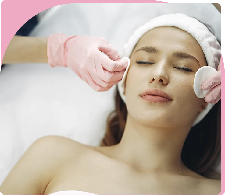 A woman getting her face cleaned by two hands.