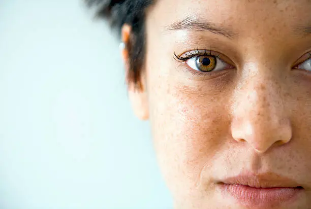 A close up of the face of a woman with brown eyes.